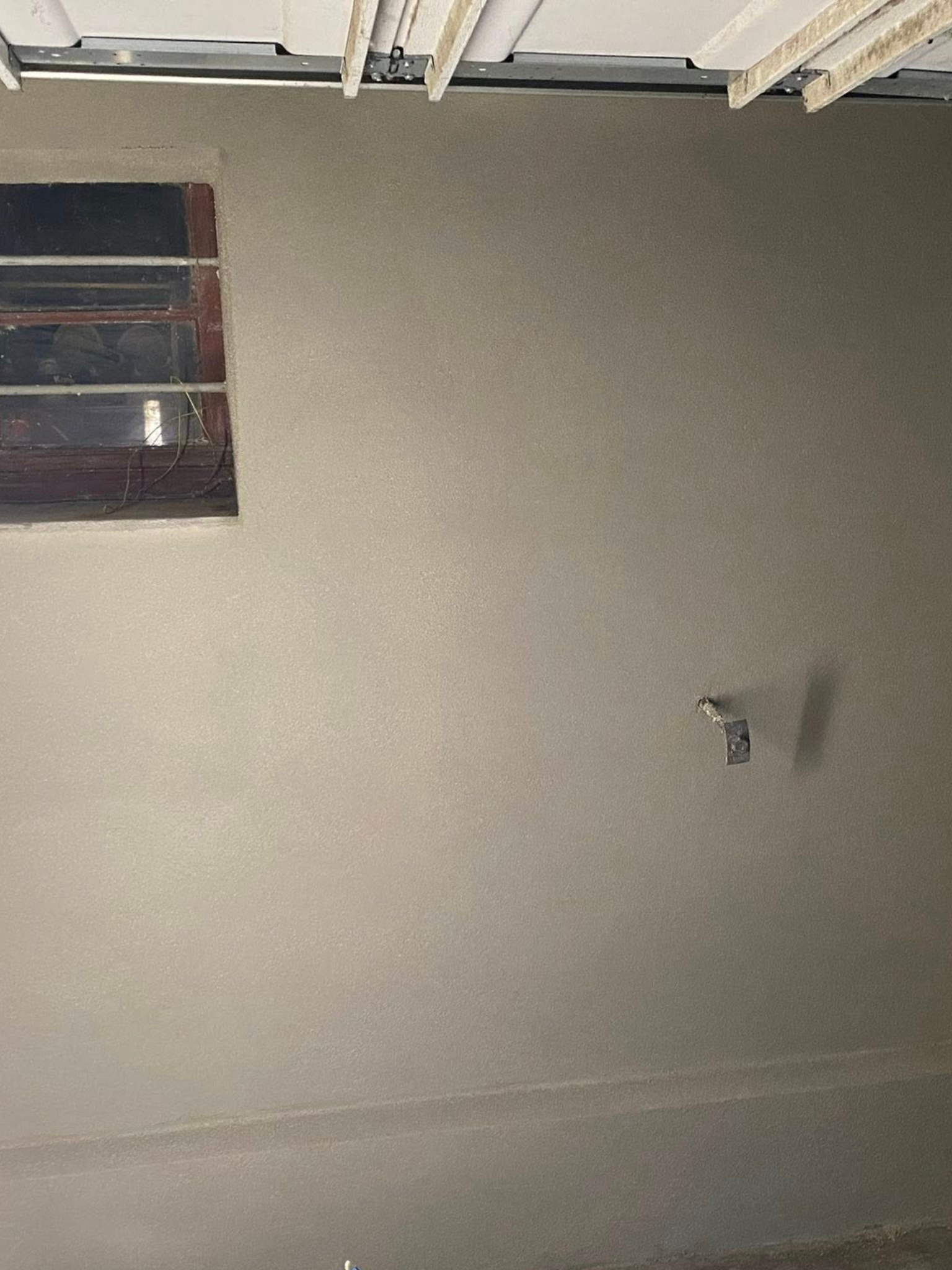 Projection d’un enduit et finition talochée dans un garage – MS Façade