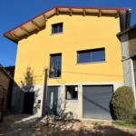 Façade de maison neuve avec sous-enduit ciment/chaux, trame en fibre de verre et enduit de finition à la chaux grattée réalisée par Les Couleurs MS.