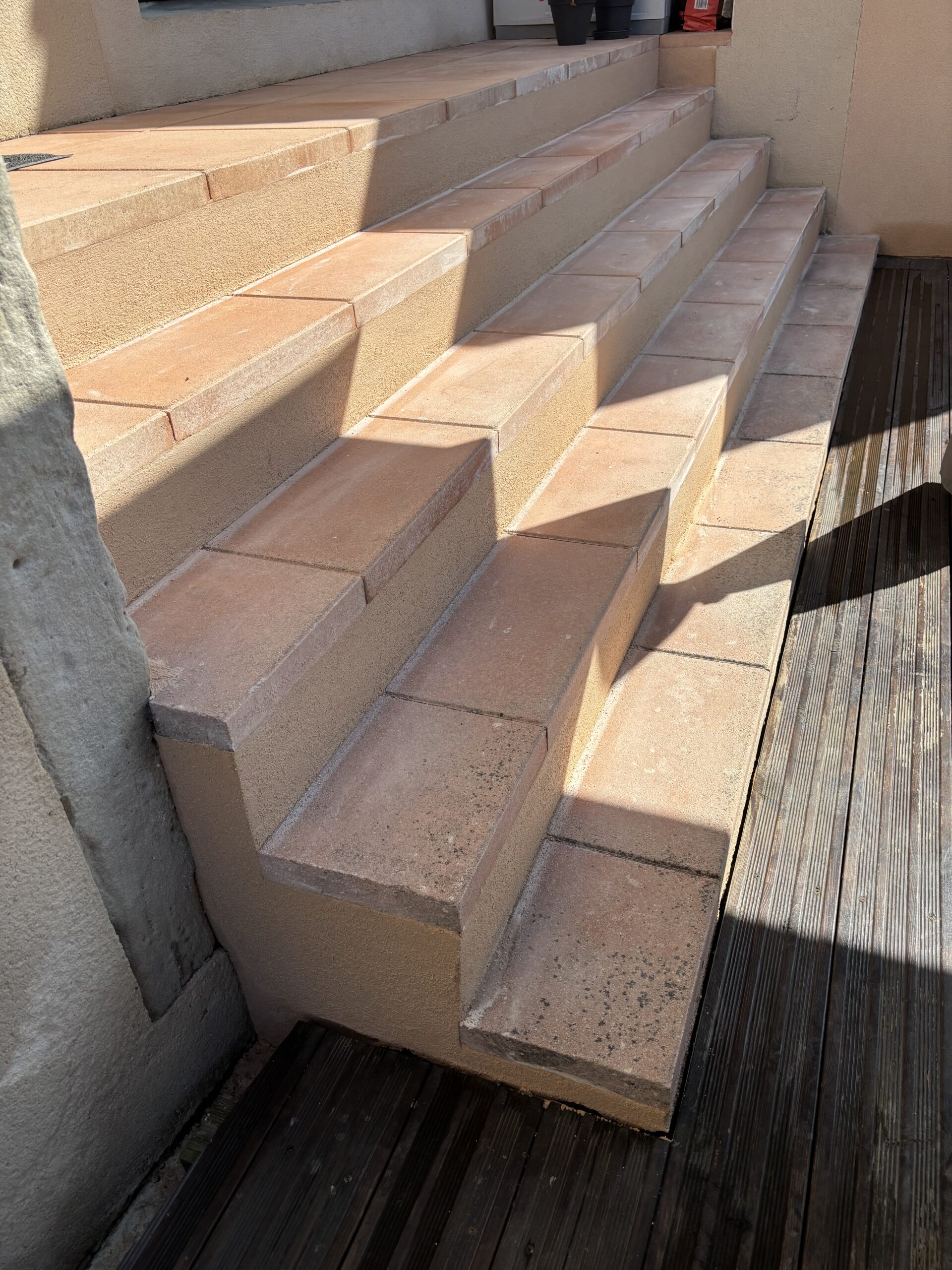 Escaliers avec enduit en finition talochée, réalisés par Les Couleurs M.S., présentant une surface texturée uniforme et propre.