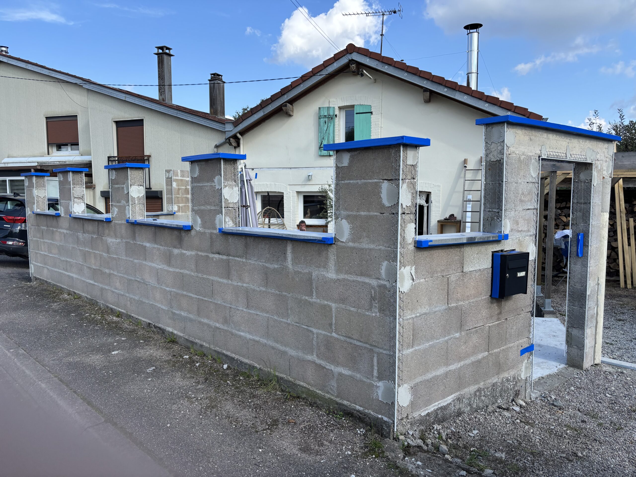 Préparation de chantier sur murette avant enduit avec protection des surfaces, pose de baguettes d'angle et travaux de calfeutrement pour assurer l'étanchéité et la qualité de finition.