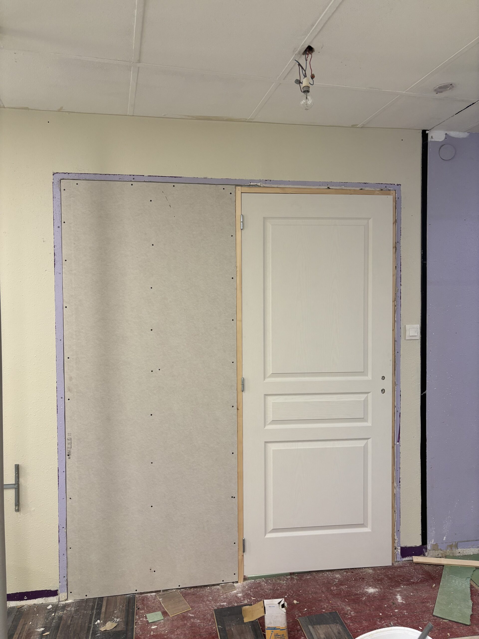 Pose d’une porte intérieure avec réglage du bâti et finitions dans le cadre de travaux de rénovation intérieure.