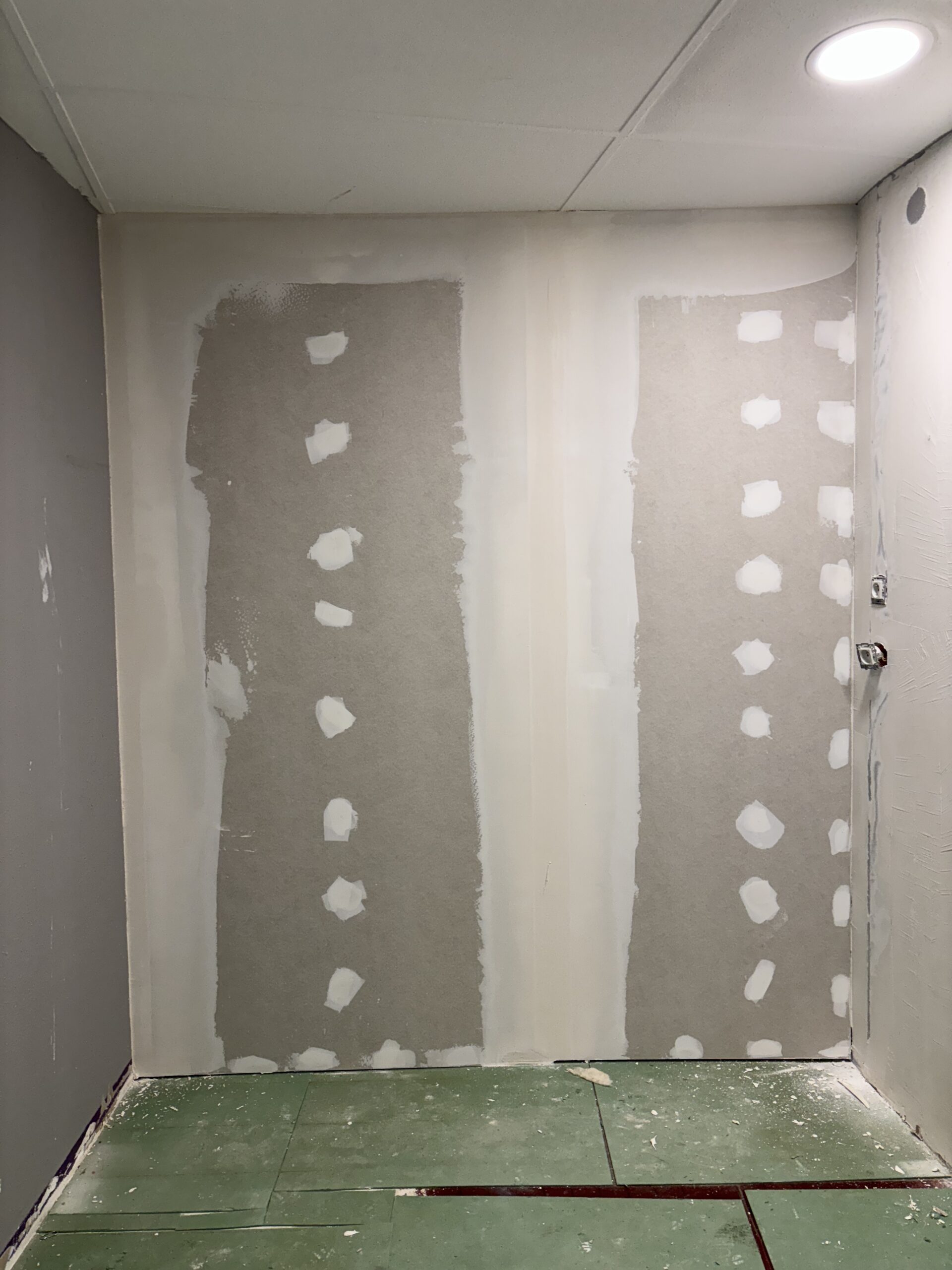 Installation de plaques de plâtre avec bandes à joint sur ossature métallique dans le cadre d’une rénovation intérieure.