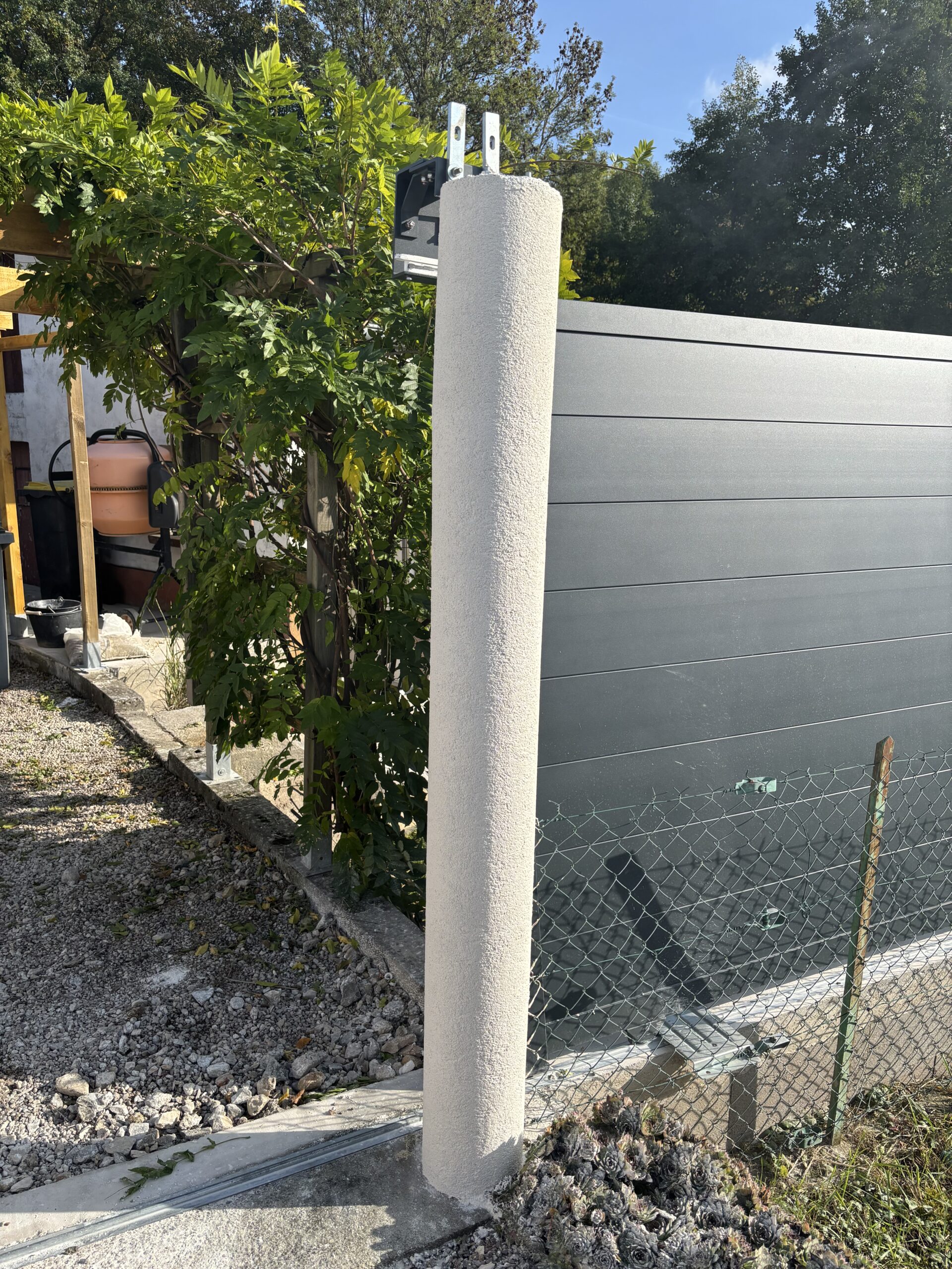 Poteaux de portail rénovés à Vincey (88) avec application d'un enduit RPE finition grésée pour une protection durable et un rendu esthétique.
