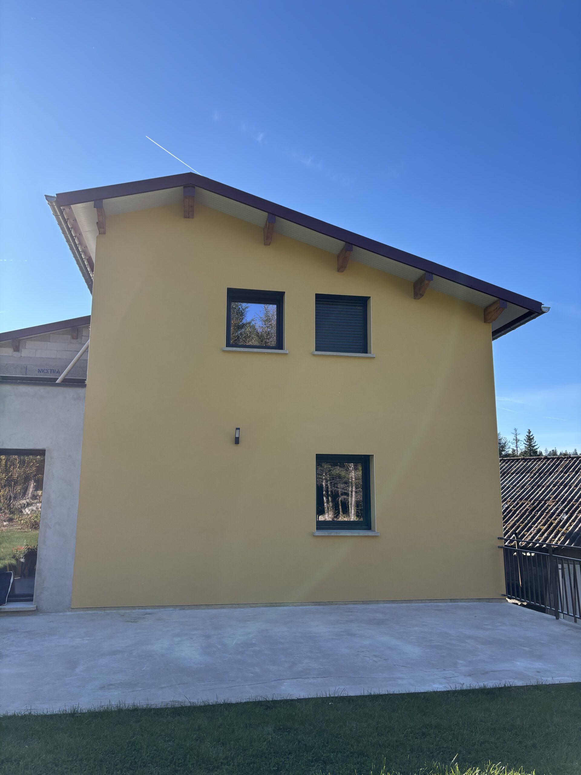 Façade de maison neuve en enduit à la chaux finition grattée avec sous-enduit ciment/chaux et trame en fibre de verre – Les Couleurs MS.