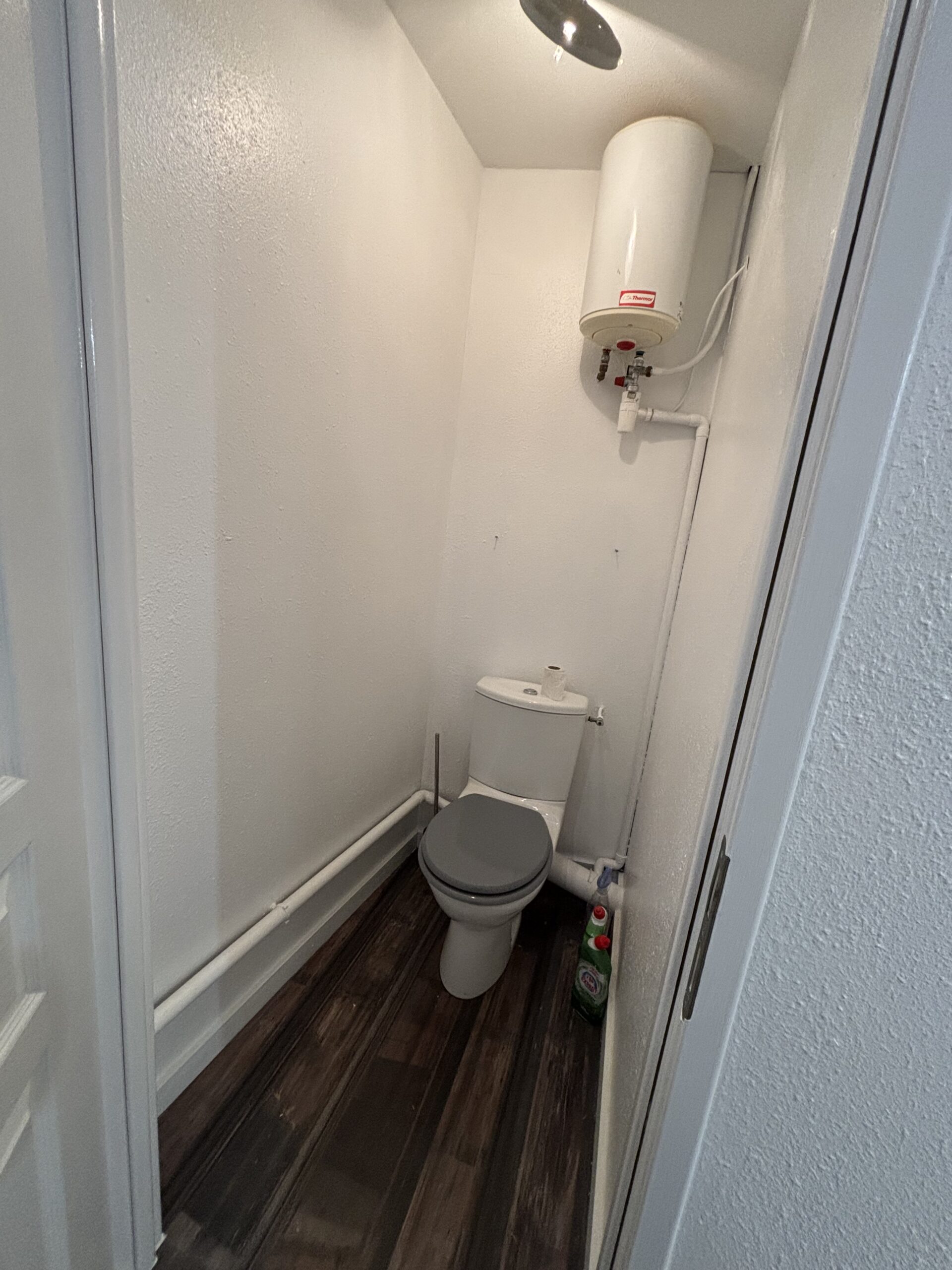 Travaux de peinture des murs et plafonds avec pose d’un parquet flottant dans le cadre d’une rénovation intérieure.
