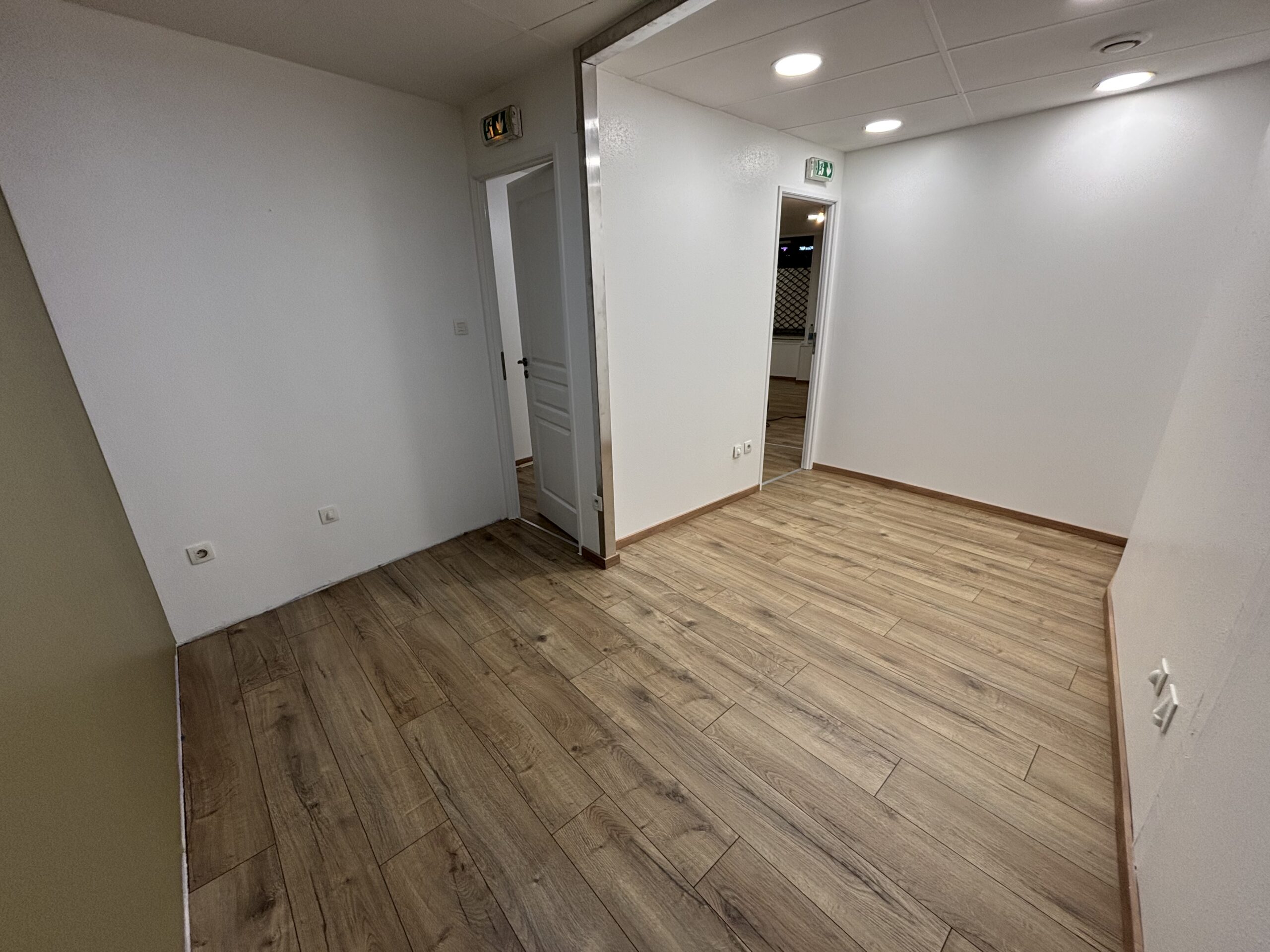Travaux de peinture des murs et plafonds avec pose d’un parquet flottant dans le cadre d’une rénovation intérieure.
