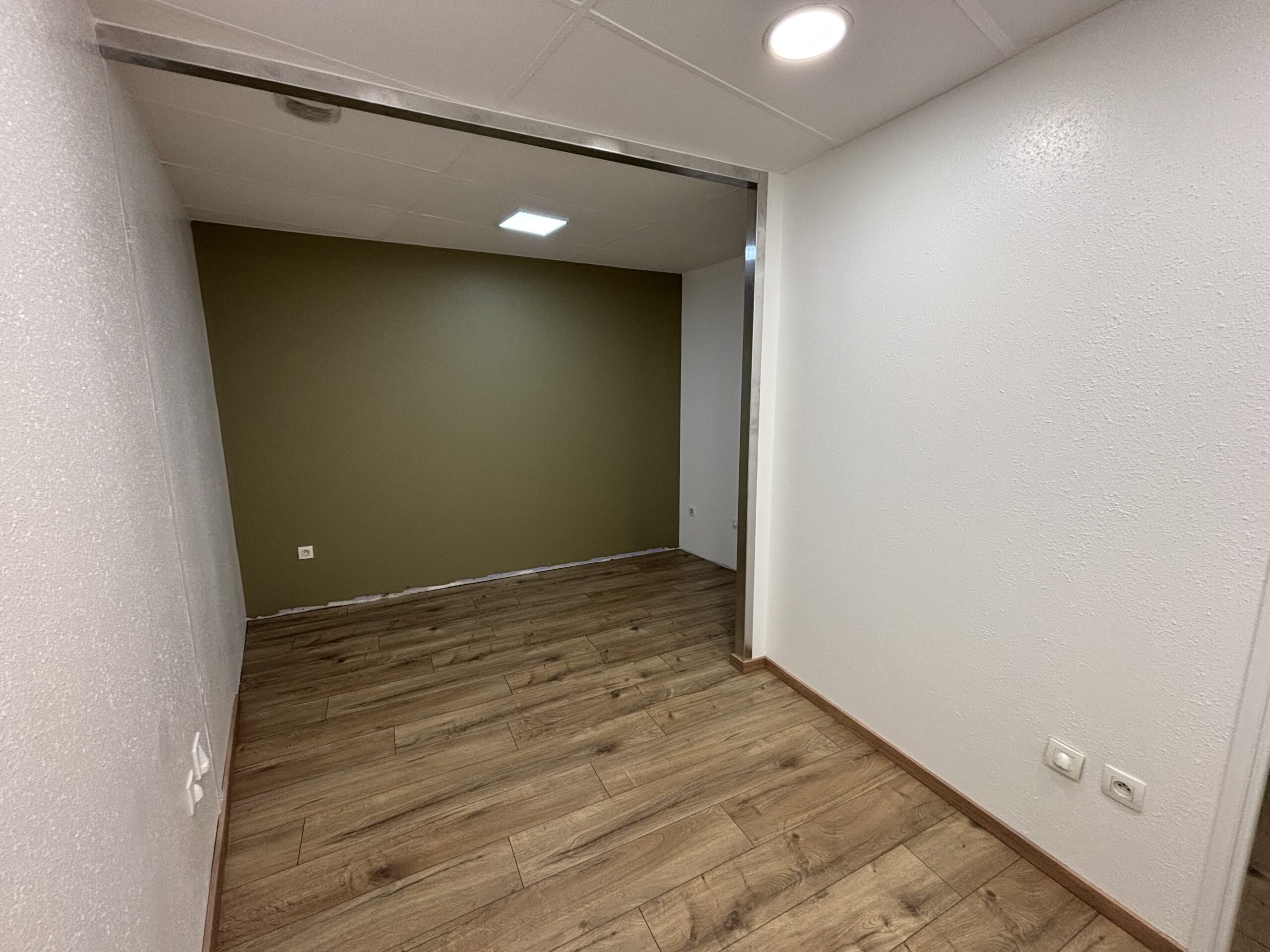 Travaux de peinture des murs et plafonds avec pose d’un parquet flottant dans le cadre d’une rénovation intérieure.