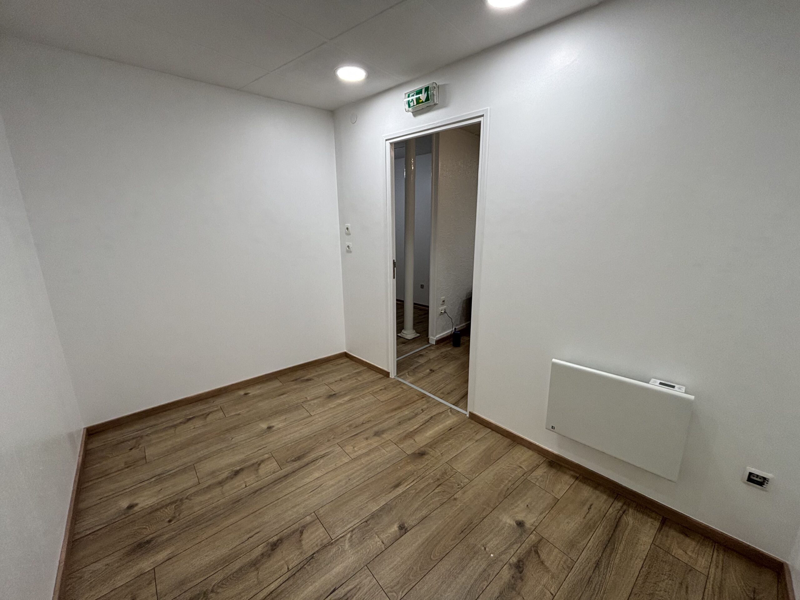 Travaux de peinture des murs et plafonds avec pose d’un parquet flottant dans le cadre d’une rénovation intérieure.