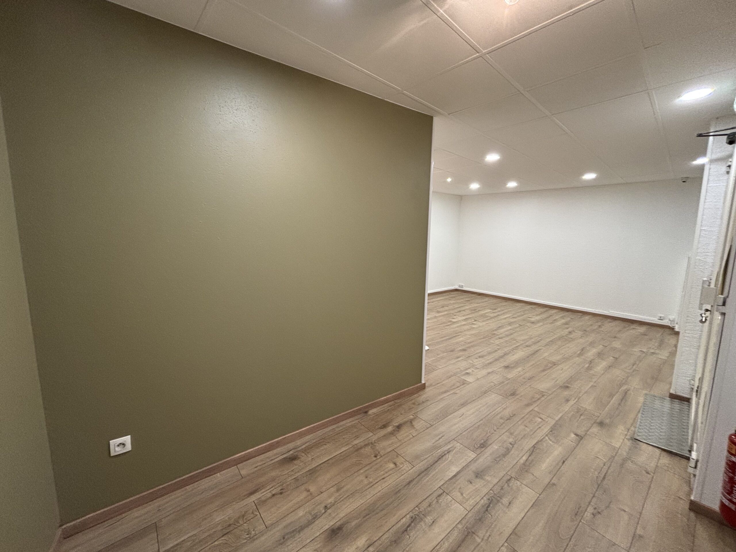 Travaux de peinture des murs et plafonds avec pose d’un parquet flottant dans le cadre d’une rénovation intérieure.
