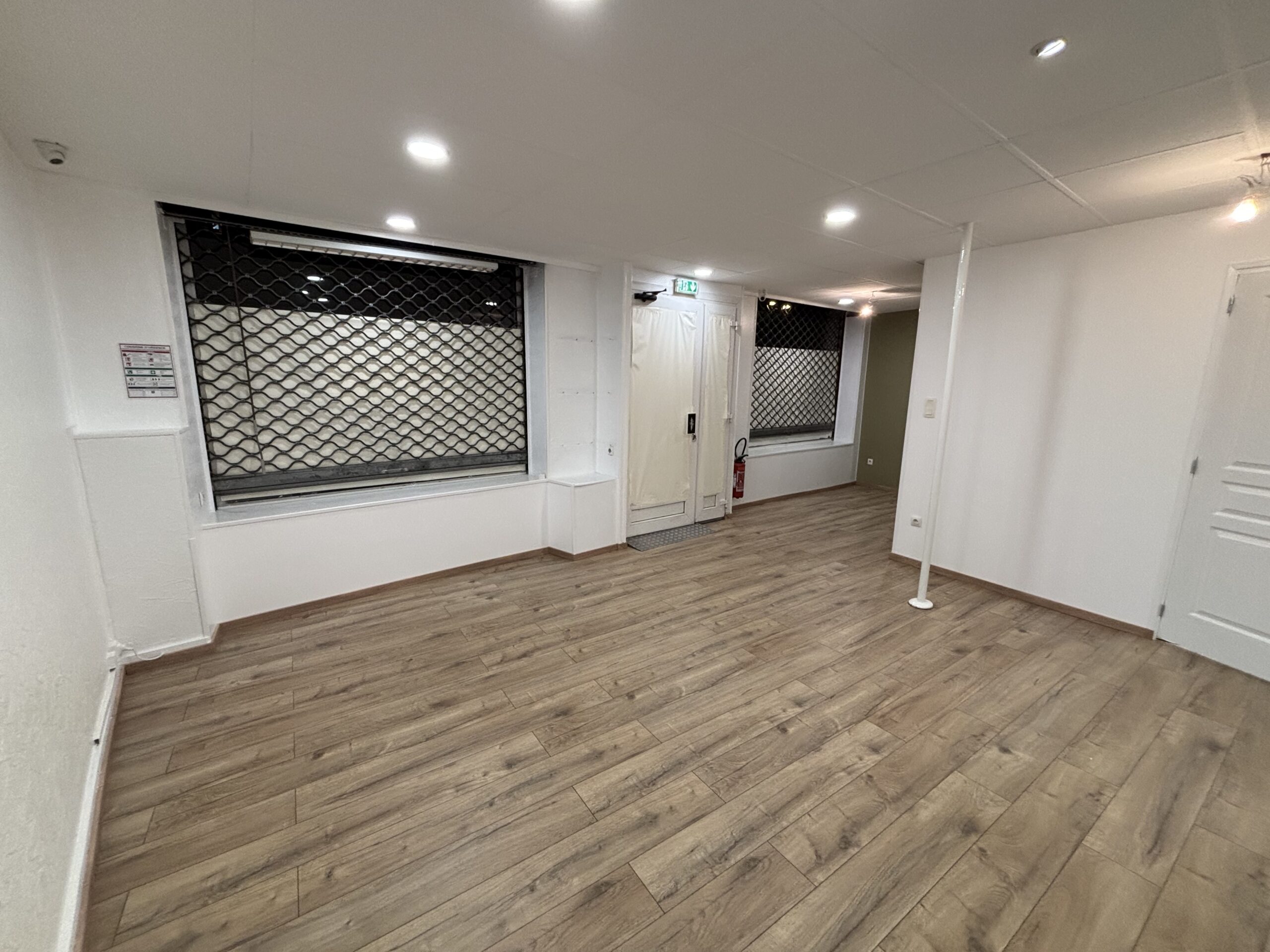 Travaux de peinture des murs et plafonds avec pose d’un parquet flottant dans le cadre d’une rénovation intérieure.