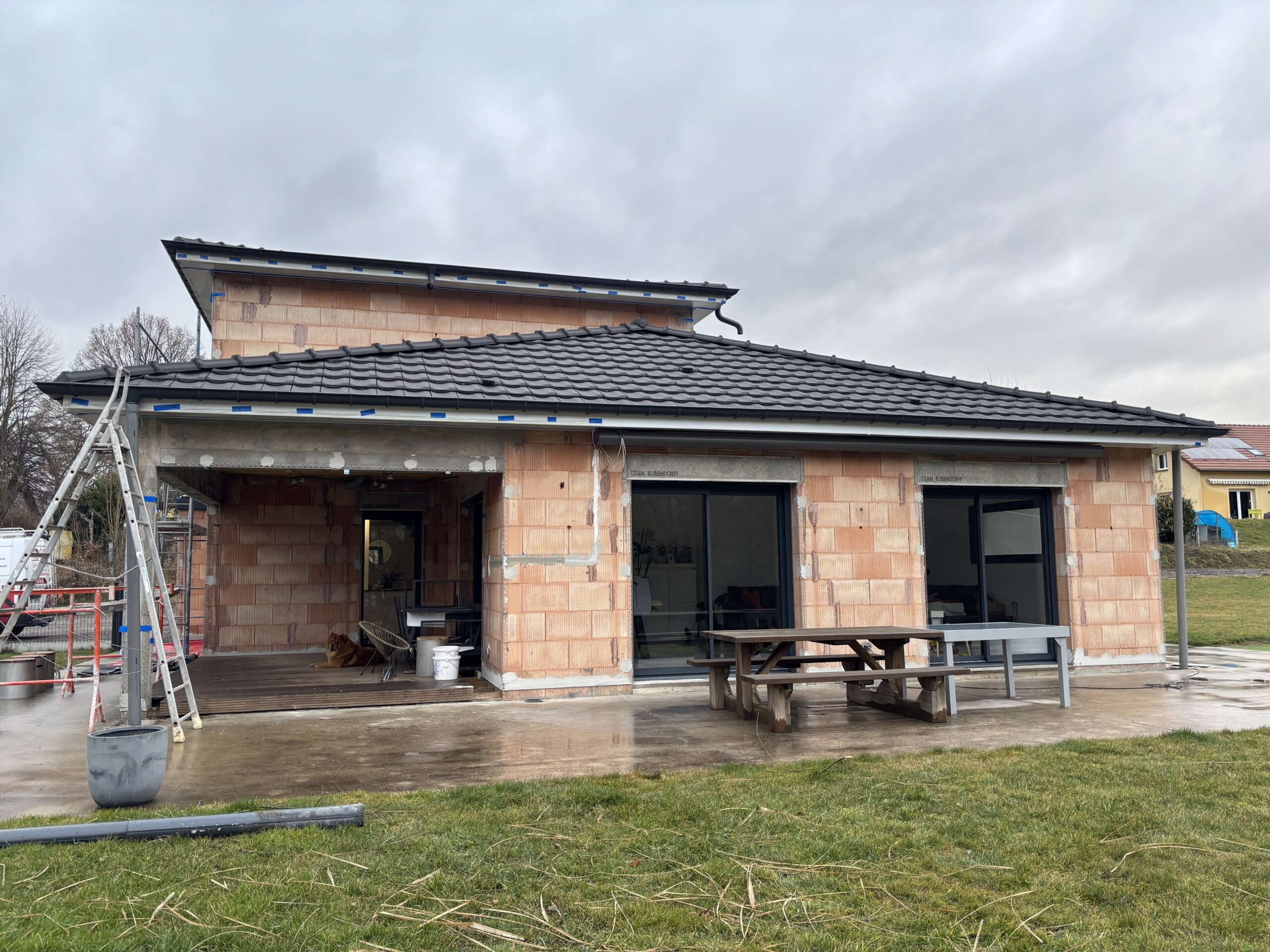 Façade avant travaux d’une maison neuve en brique à Aydoilles sans enduit extérieur.