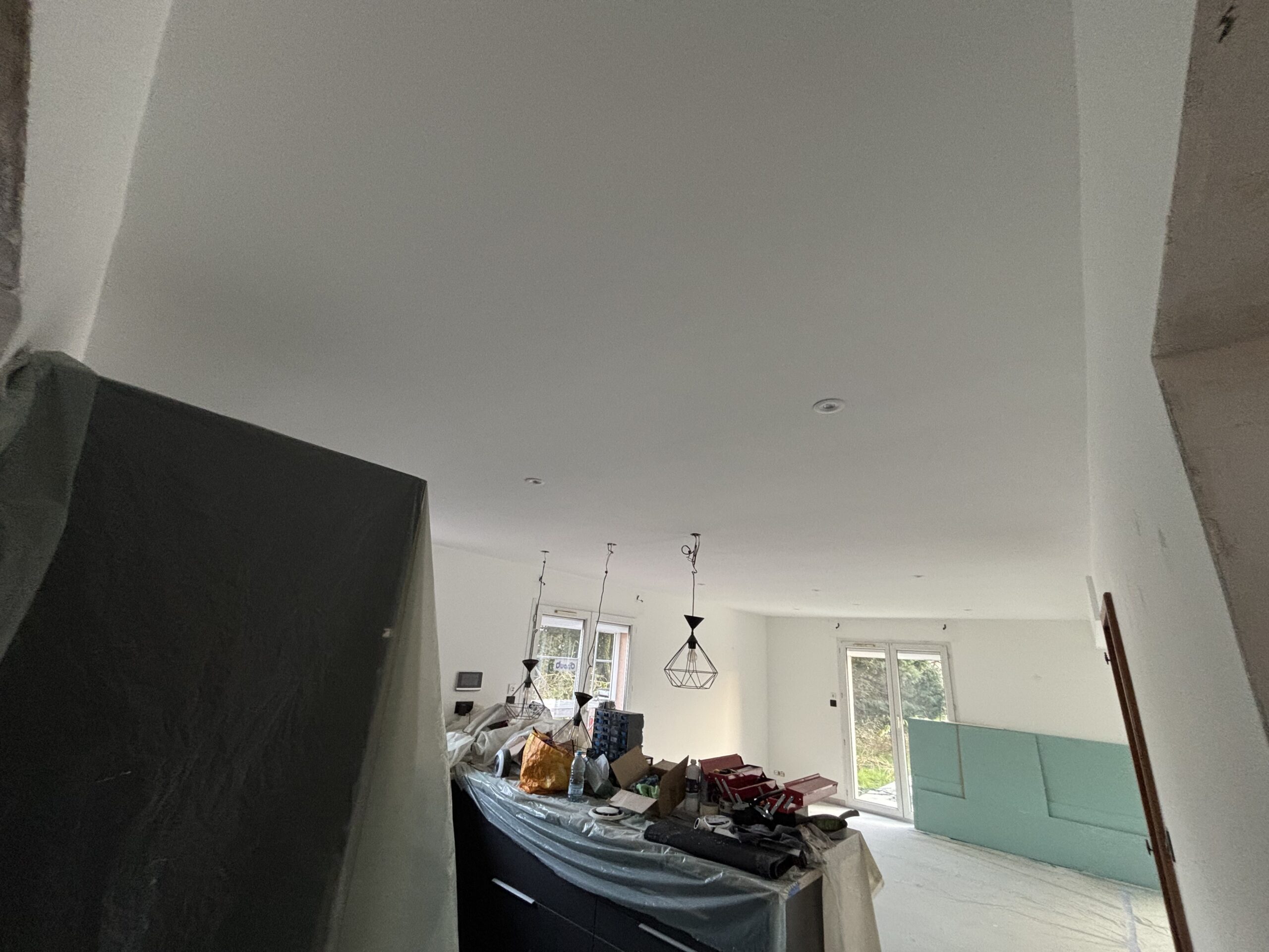 Plafond rénové avec enduit, ponçage et peinture finition blanche mate.