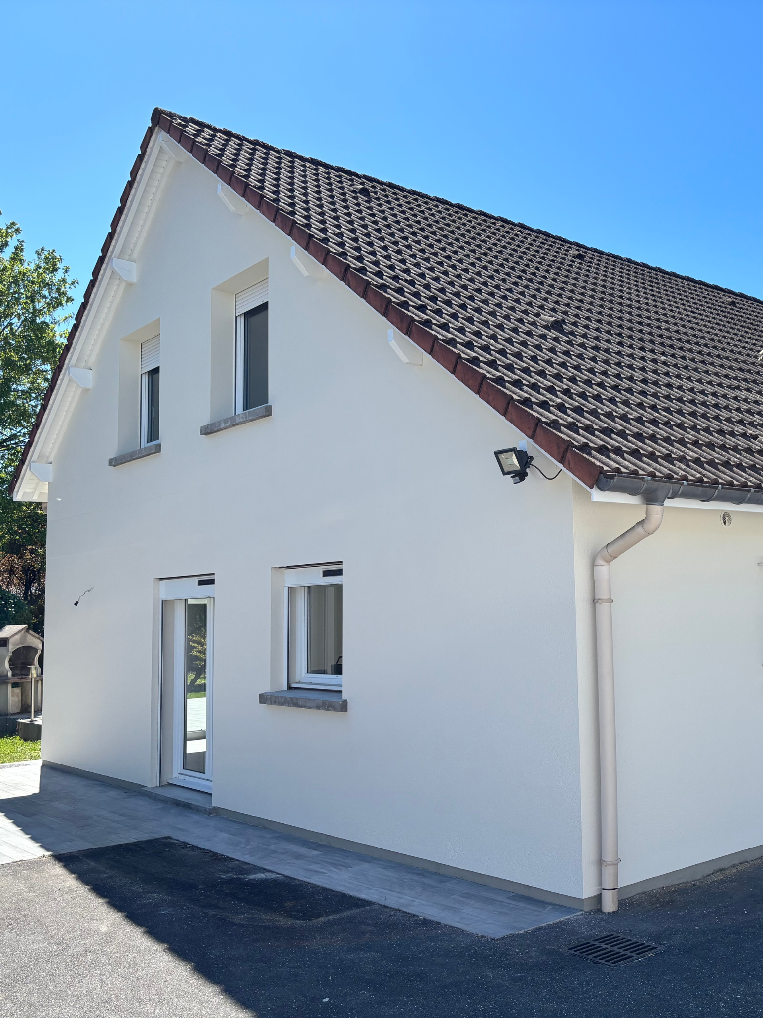 Peintre réalisant la peinture d’une façade de maison à Rambervillers dans les Vosges